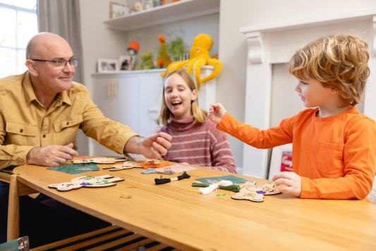 Parent and children enjoying a craft activity which teaches beginner hand sewing
