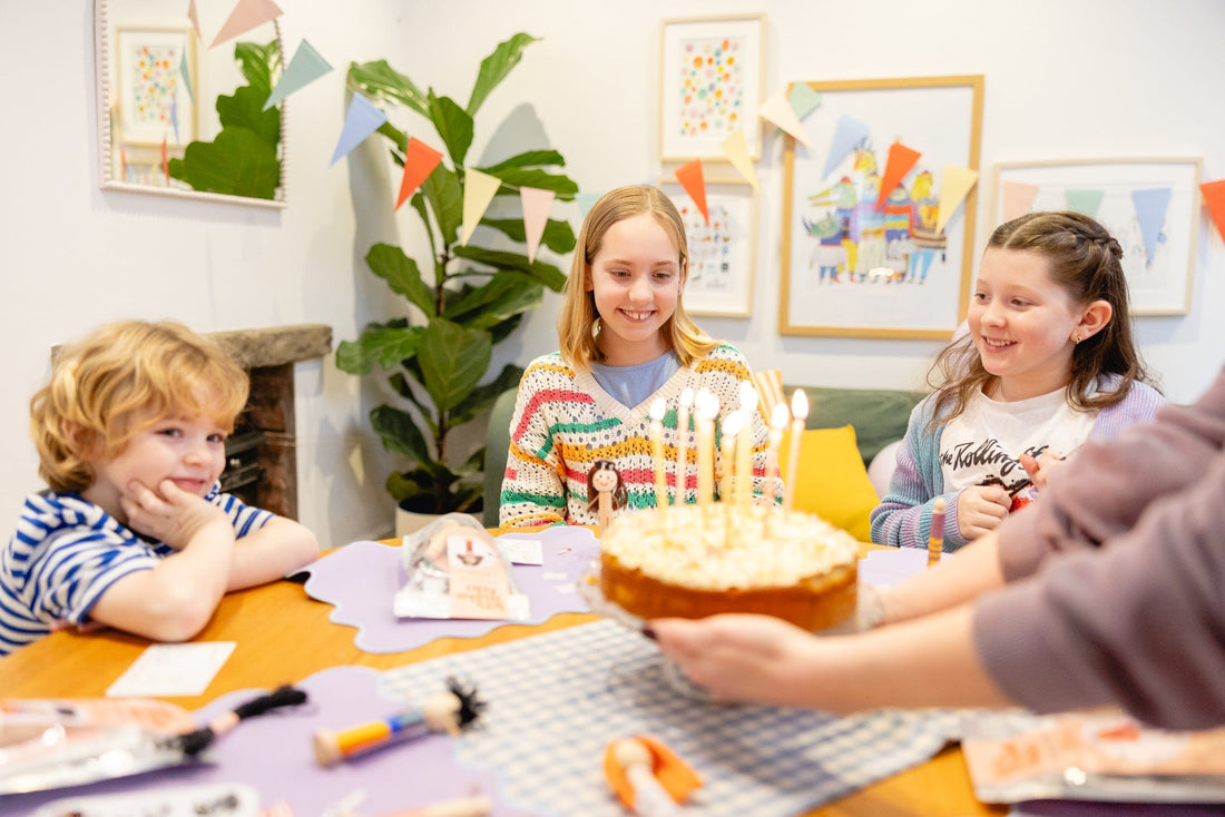 Children enjoying a craft birthday party with peg doll craft kits laid on the table